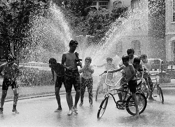 Children play under the spray of an open fire hydrant (ST-20001434-0020)